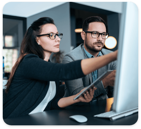 Two people looking at a computer screen, pointing at features within the legal estate planning software